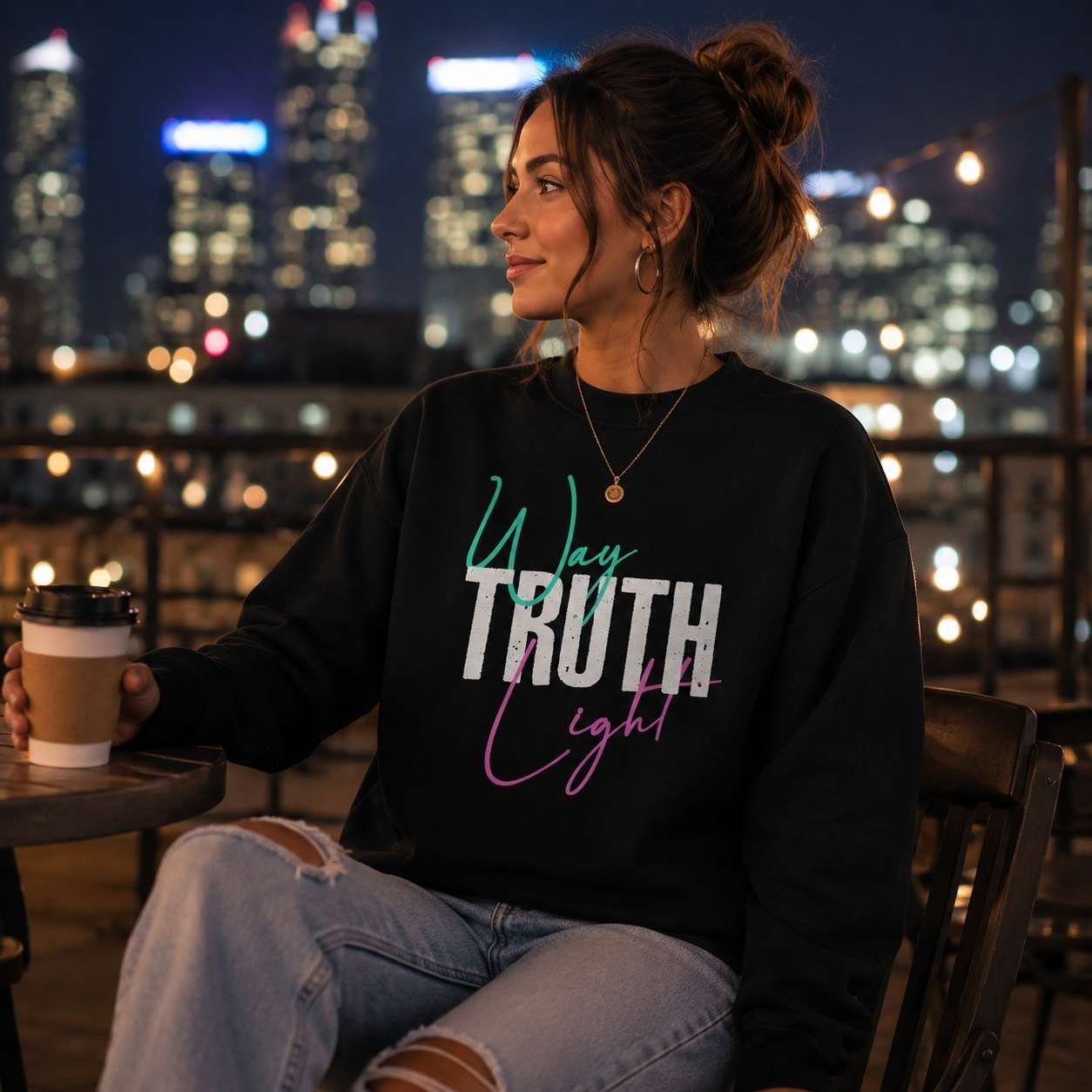 Woman wearing a black Way Truth Light faith-inspired sweatshirt.